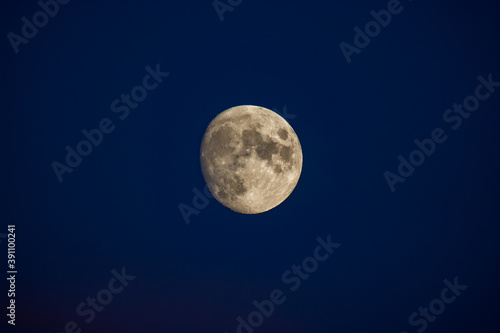 Night black sky and yellow moon with visible craters