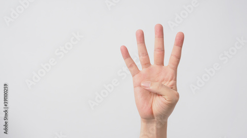 A hand sign of 4 fingers point upward meaning four.It put on white background © nisara