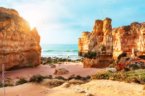 Beautiful beach with yellow sand and rocks in Algarve  Portugal. Shore of Atlantic ocean. Beautiful summer seascape  famous travel destination