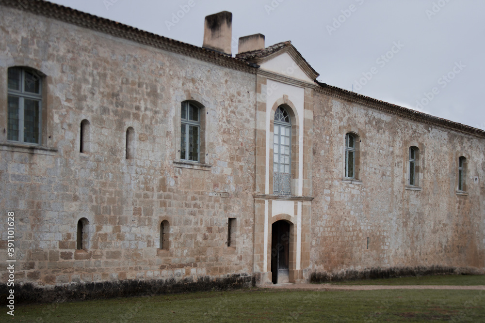 Perspective view of old sandstone facade. Grunge texture. Regular facade with porch in the middle.