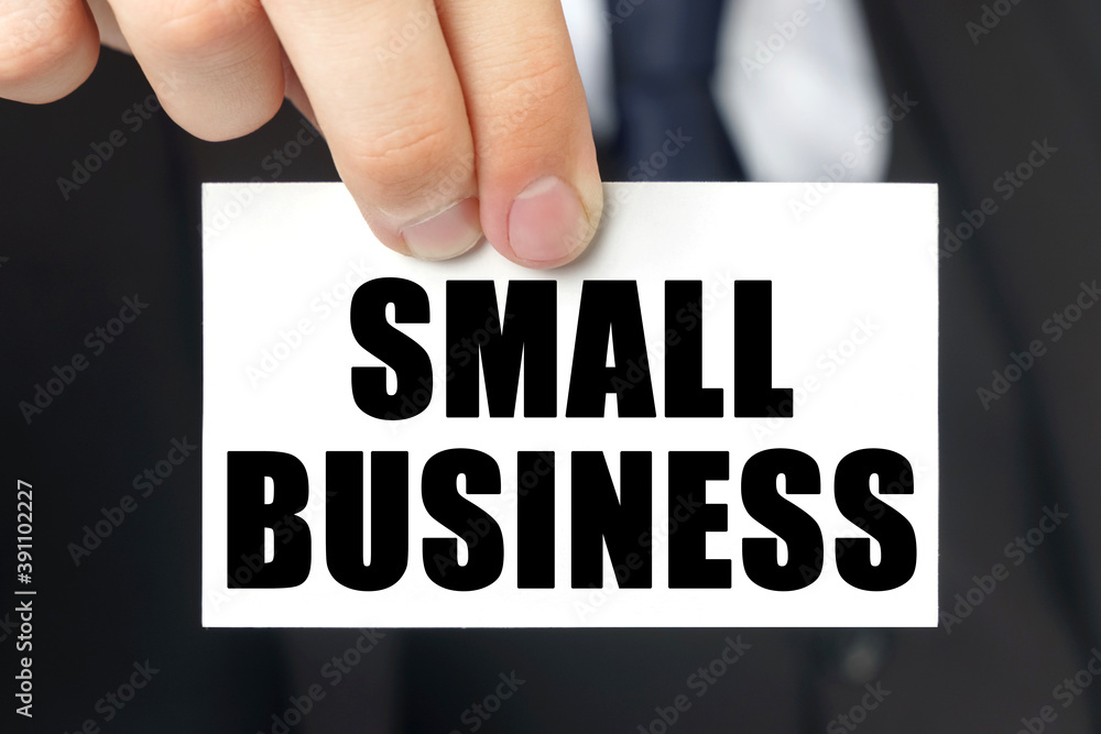 Businessman shows a card with the text SMALL BUSINESS Businessman shows a card with the text SMALL BUSINESS