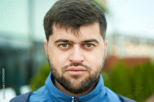 Young white bearded attractive man with serious look outdoor.