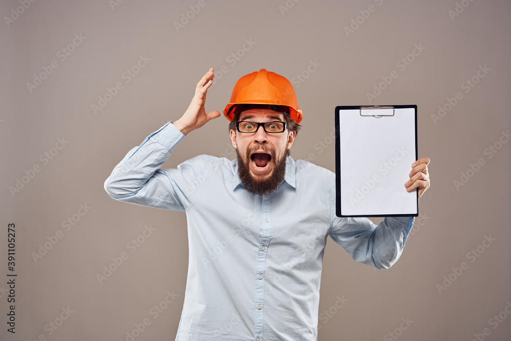 A man in a shirt with an orange hard hat engineer work documents rendering services A man in a shirt with an orange hard hat engineer work documents rendering services