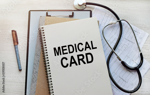 On the notebook there is an inscription on a medical theme. Top view of a notebook with medical records and a stethoscope. healthcare concept