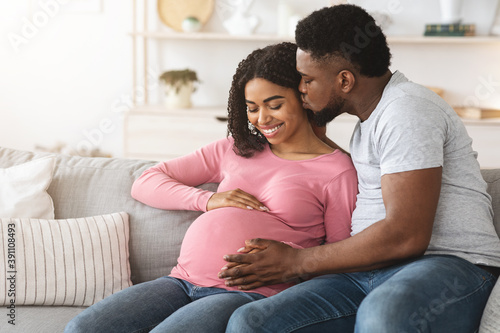 Black man kissing his happy pregnant wife