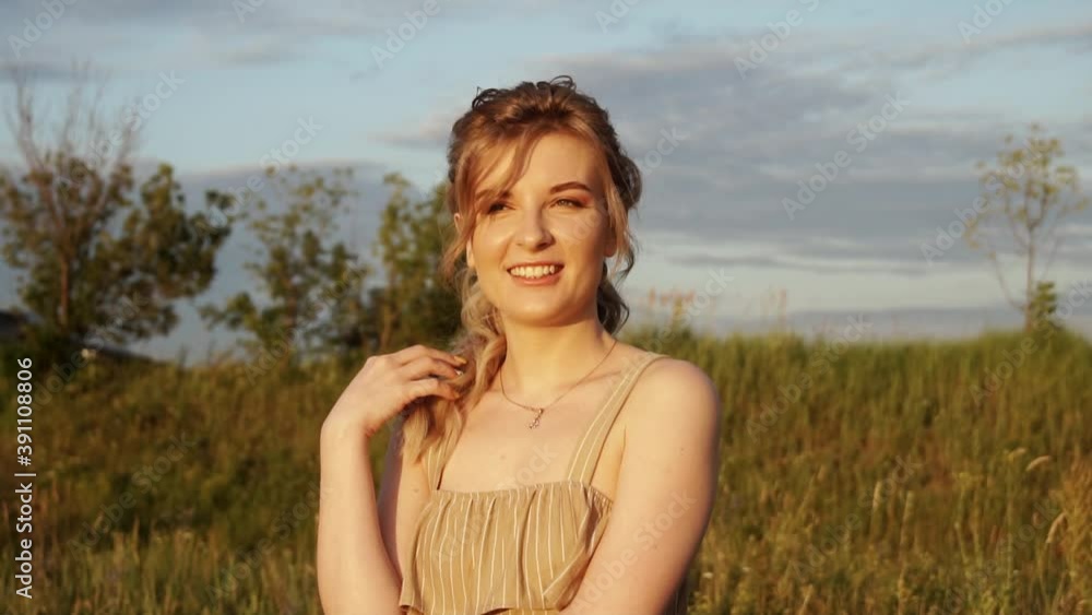 Head and shoulders portrait of smiling young woman outdoors in countryside - shot in slow motion Head and shoulders portrait of smiling young woman outdoors in countryside - shot in slow motion
