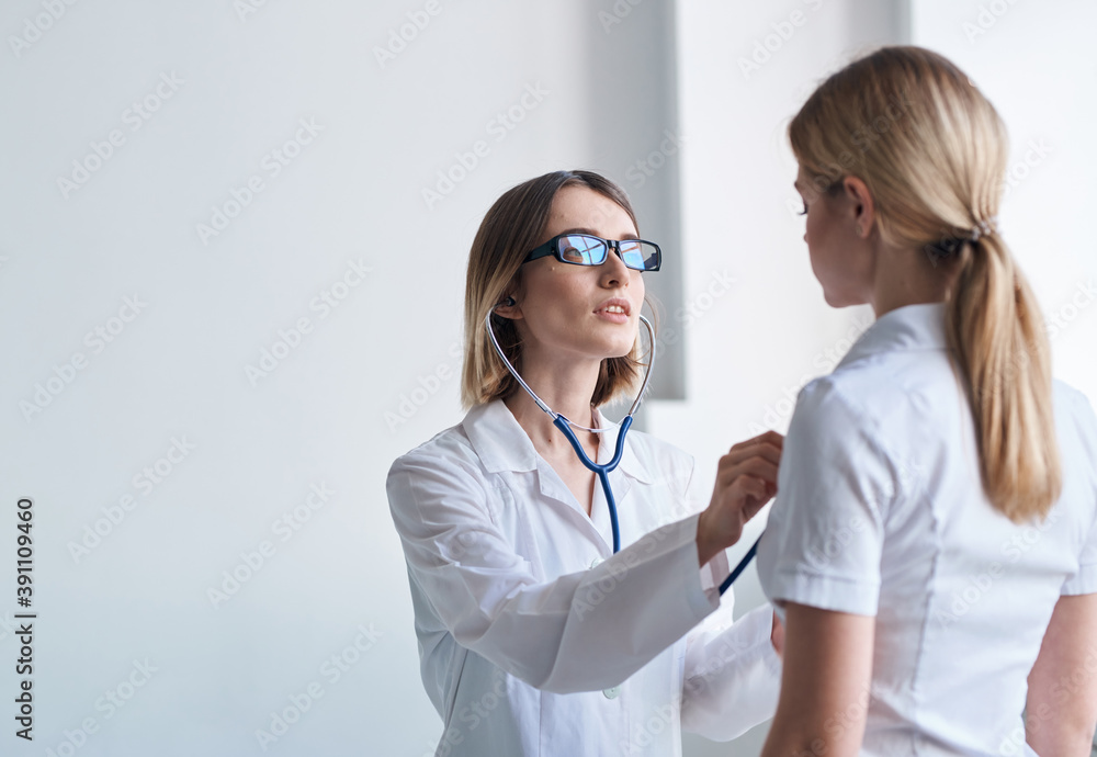 Woman doctor with stethoscope and glasses examines the patient health model Woman doctor with stethoscope and glasses examines the patient health model