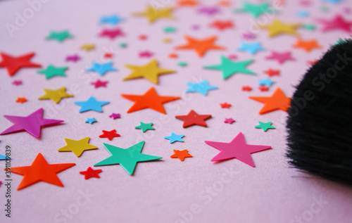 Colorful stars confetti festive decoration on a pink pastel background. photo