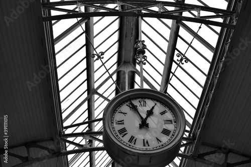 Antique railway station clock in black and white.