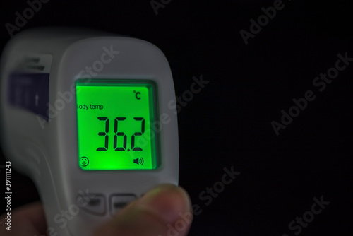 Infrared no touch thermometer monitor on a black background, isolated, close up