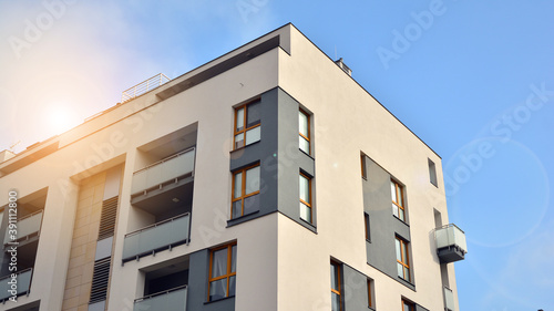 Exterior of a modern multi-story apartment building - facade, windows and balconies.