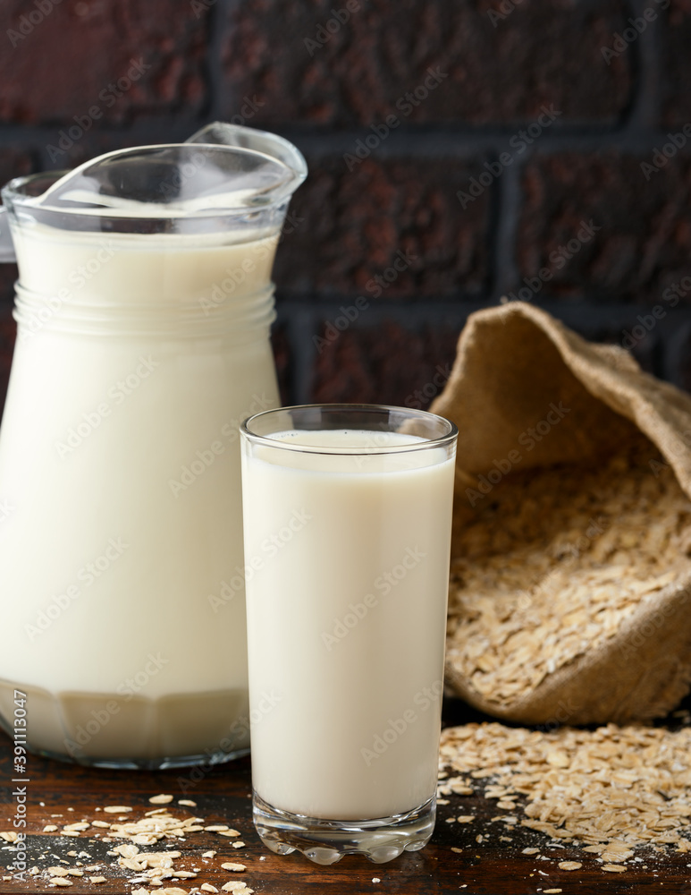 Vegan Oat milk in glass on rustic wooden table Vegan Oat milk in glass on rustic wooden table