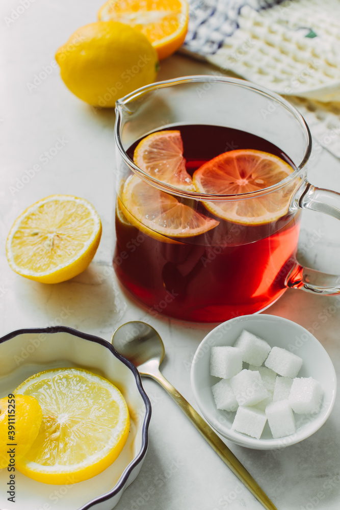 Red lemonade with citruses on a light background. Still life.