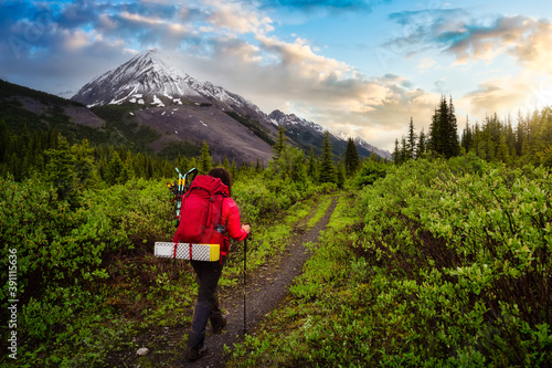 Female Backpacker Hiking in Canadian Rockies. Sunset Sky. Taken near Banff, boarder of British Columbia and Alberta, Canada. Concept: Explore, Adventure, Trekking, Backpacking © edb3_16