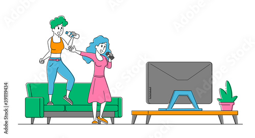 Cheerful Girls Couple Singing Song in Karaoke Standing with Microphones front of Tv Screen at Home. Characters Sparetime