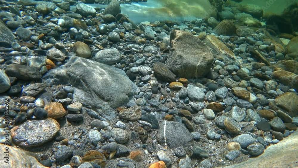 The fast flowing waters of the mountain river sharpen the stone and create incredible patterns. Underwater view. The fast flowing waters of the mountain river sharpen the stone and create incredible patterns. Underwater view.