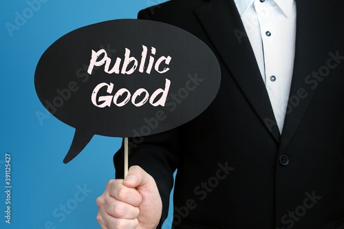 Public Good. Businessman holds speech bubble in his hand. Handwritten Word/Text on sign.