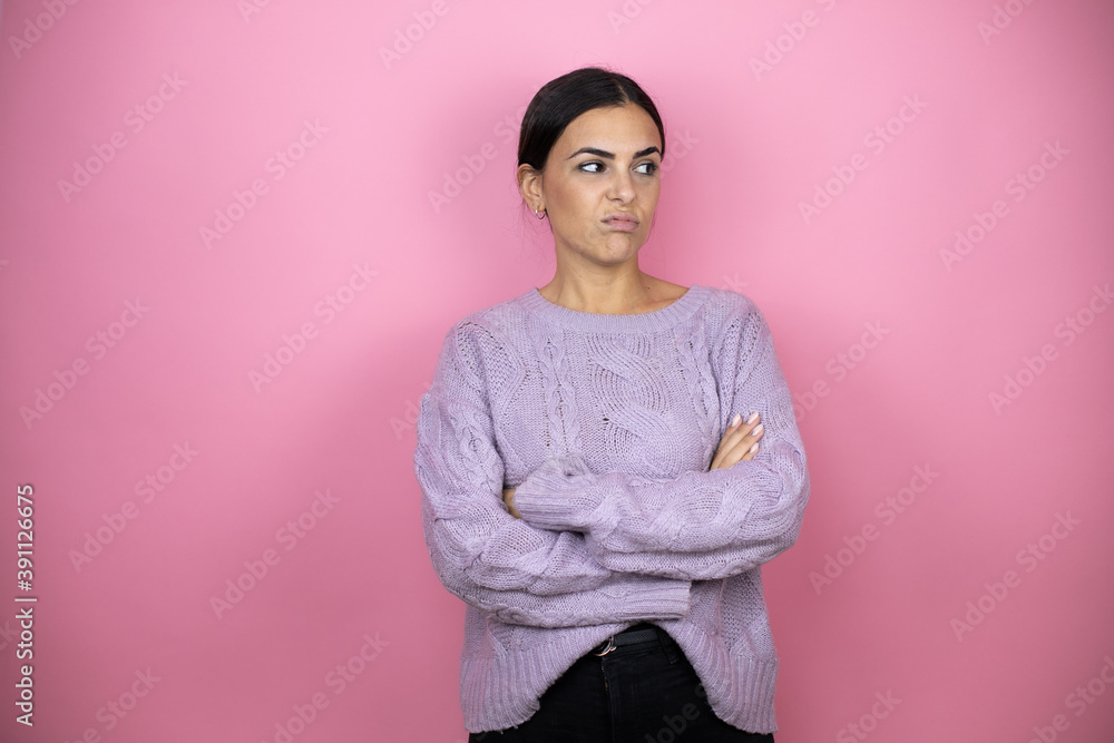 Obraz premium Beautiful woman wearing a casual violet sweater over pink background thinking looking tired and bored with crossed arms