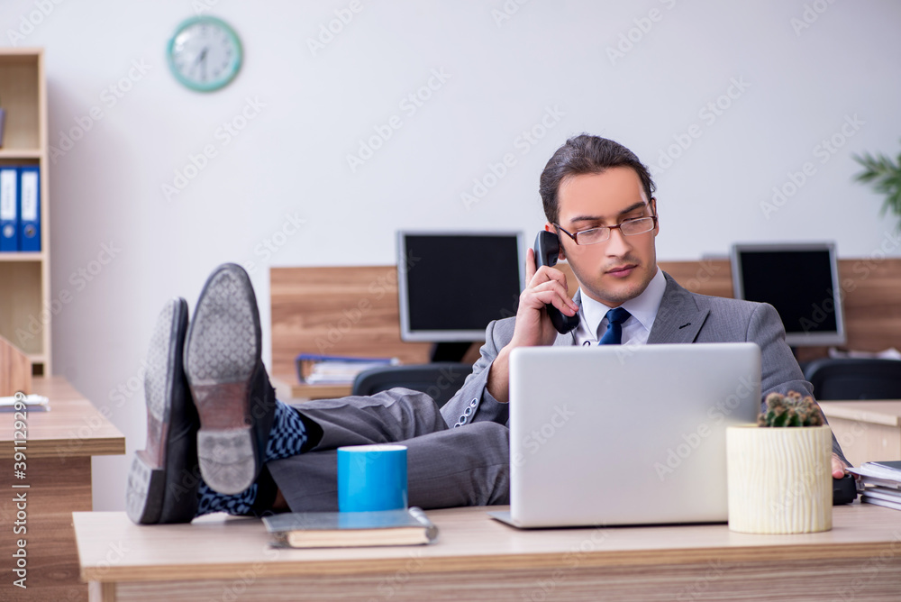 Young male employee working in the office Young male employee working in the office