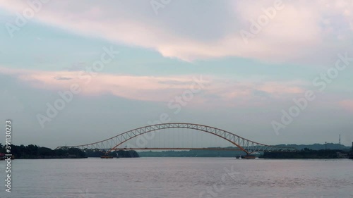 Bridge and cloud motion time lapse, Kutai Kartanegara bridge over Mahakam river, Tenggarong Indonesia, circa November 2020 photo