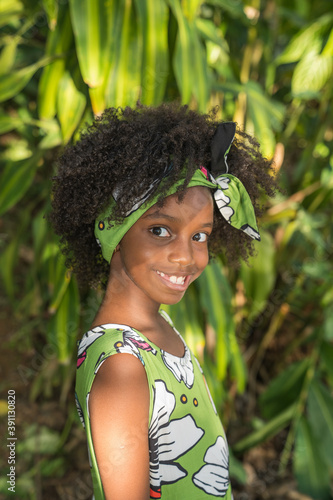 Closeup portrait of Young black girl with afro hairstyle smilling at camera.