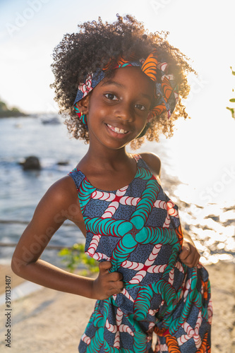Closeup portrait of Young black girl with afro hairstyle smilling at camera.