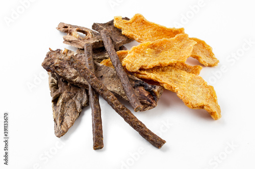 a mix of dog treats, dried chicken tenders, dried beef tendon, and formed beef sticks on white background