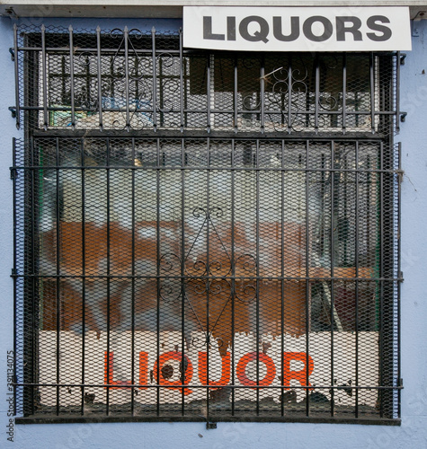Quadro em tela Barred liquor store window in rundown section of town.