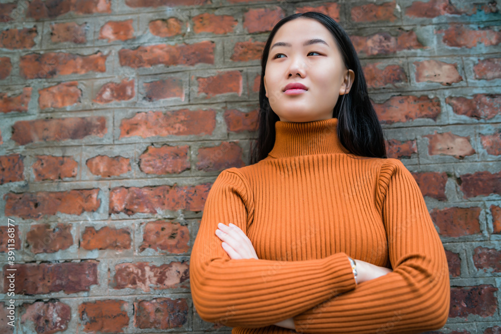 Asian woman against brick wall. Asian woman against brick wall.