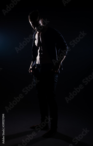 Silhouette of attractive young Caucasian man dressed casually looking at camera
