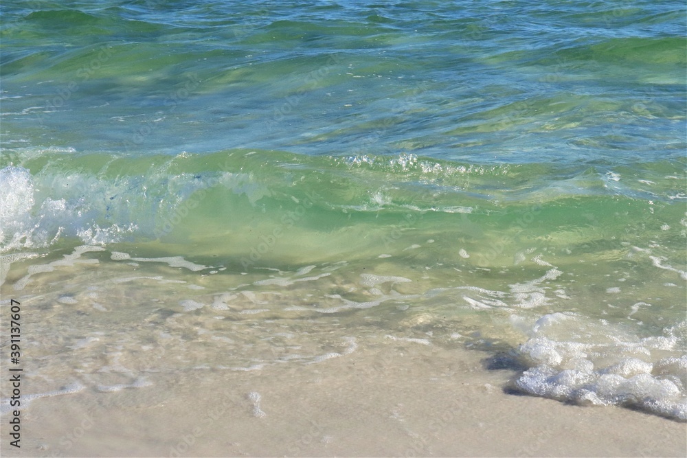 On the beach - ocean water, yellow sand, white foam on the water, close-up On the beach - ocean water, yellow sand, white foam on the water, close-up