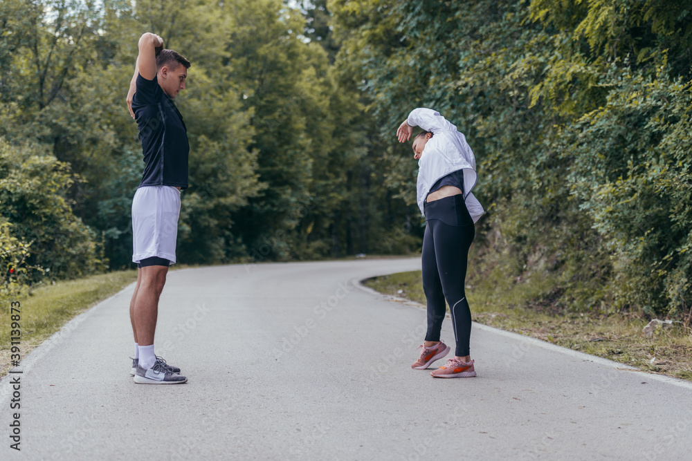 Fototapeta premium Male and female athletes preparing for a marathon, run, workout. Healthy lifestyle concept.