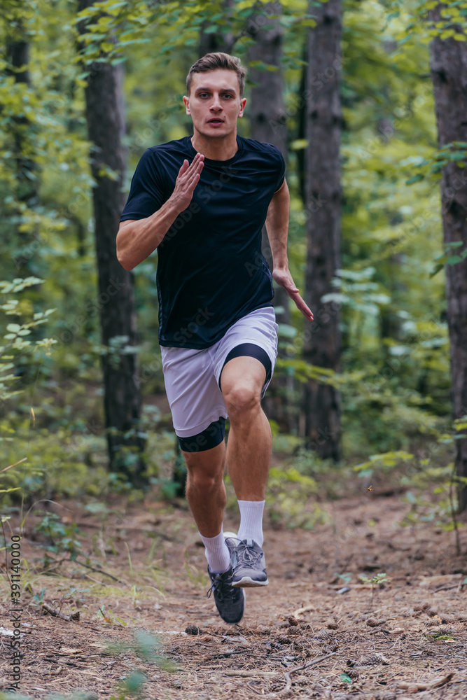 Close up picture of a handsome jogger jogging in the forest Close up picture of a handsome jogger jogging in the forest