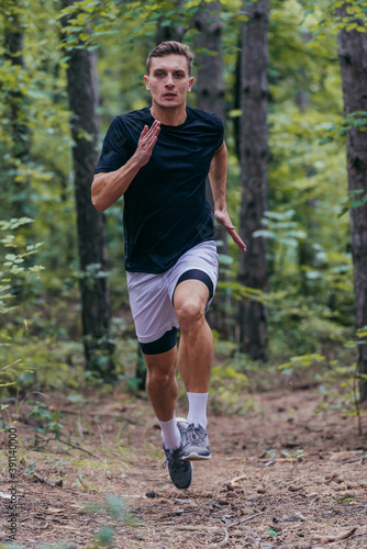 Close up picture of a handsome jogger jogging in the forest