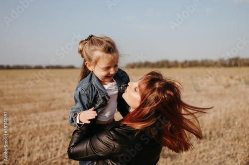 Mother walking outdoors with her little daughter