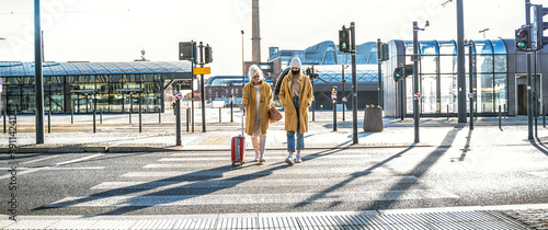 Caucasian mother visiting daughter during pandemic, walking at bus stop,