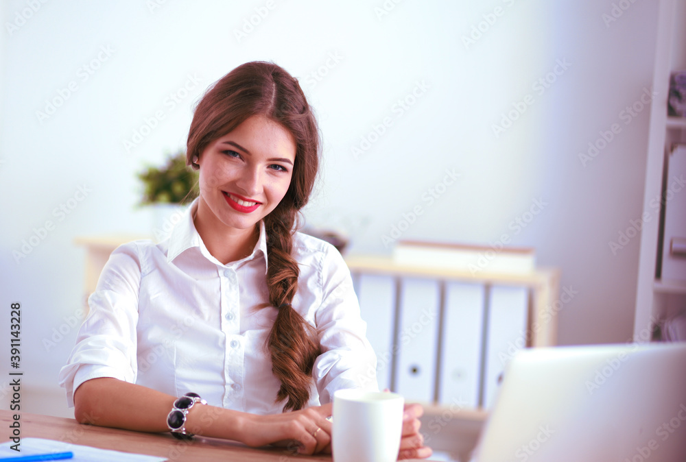 Attractive businesswoman sitting on desk in the office Attractive businesswoman sitting on desk in the office