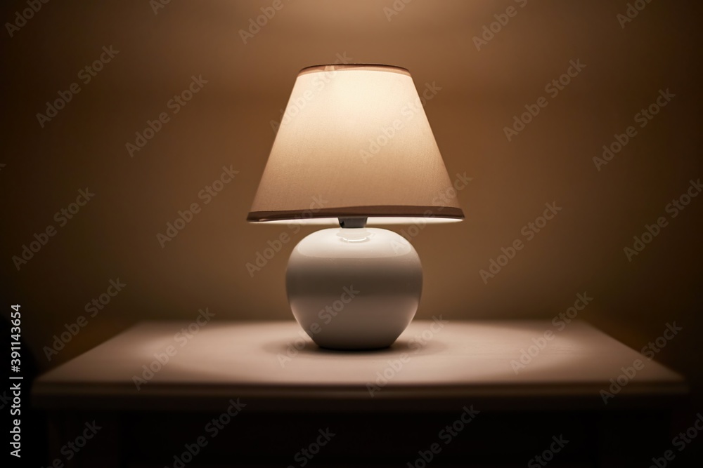 Small lamp glowing in bedroom night stand, close up, dim room Stock-Foto |  Adobe Stock