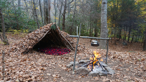 Survival Shelter Debris hut in the wilderness. Bushcraft camp setup in the forest. photo