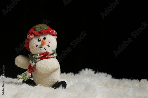 muñeco de nieve con sombrero y bufanda en fondo negro 