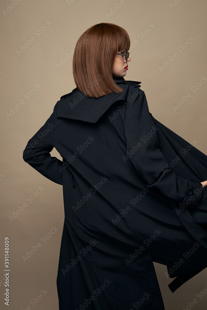 Smiling model classic coat charming smile having fun on a beige background Smiling model classic coat charming smile having fun on a beige background