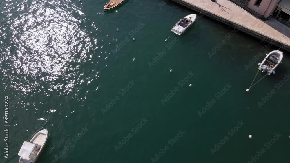 Aerial view of boat sailing on lake Garda by Sato city promenade, Lombardy Italy on sunny summer day, tilt down drone shot Aerial view of boat sailing on lake Garda by Sato city promenade, Lombardy Italy on sunny summer day, tilt down drone shot