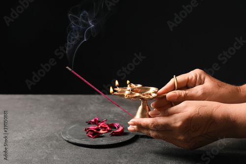 Female hands with diya lamp...