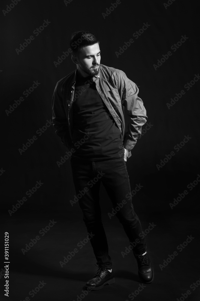Black and white portrait of fashionable young man on dark background Black and white portrait of fashionable young man on dark background