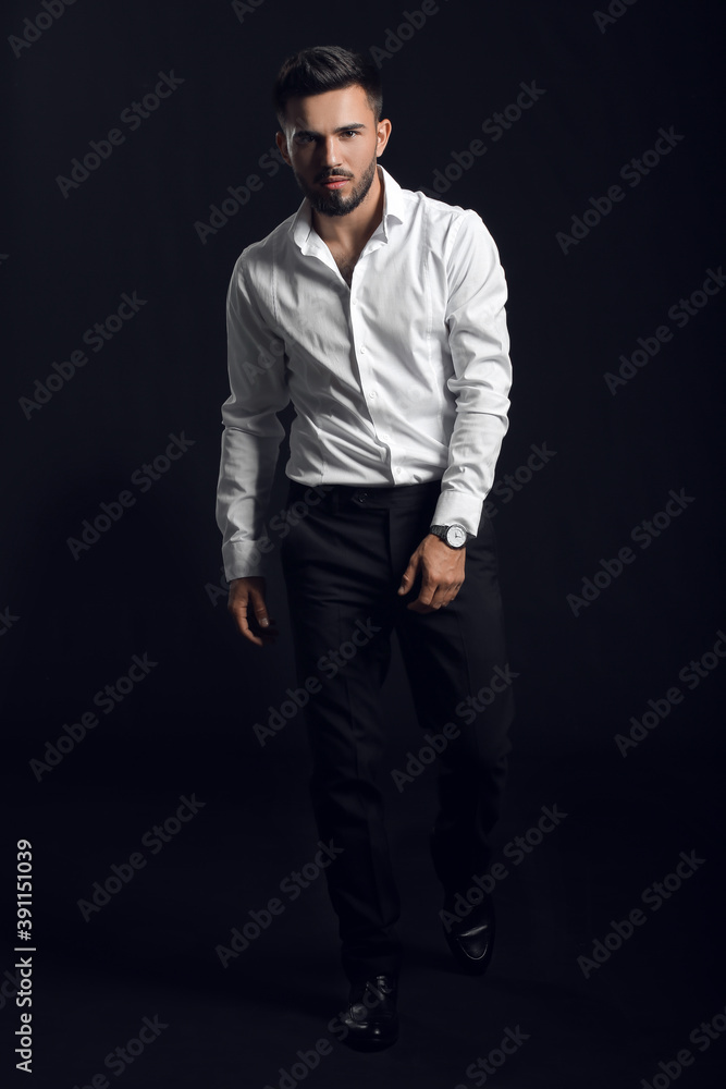 Fototapeta premium Fashionable young man on dark background