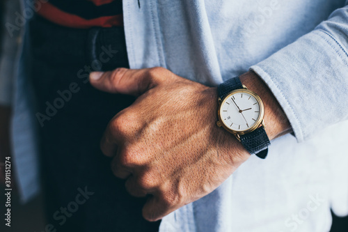 man fashionable wearing stylish looking at luxury watch on hand check the time at workplace.concept for managing time organization working,punctuality,appointment