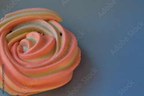 pink round meringue on a blue background. Dessert meringue close up. Beautiful sweets.