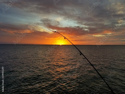 Stunning sunset with a silhouette of a fishing rod