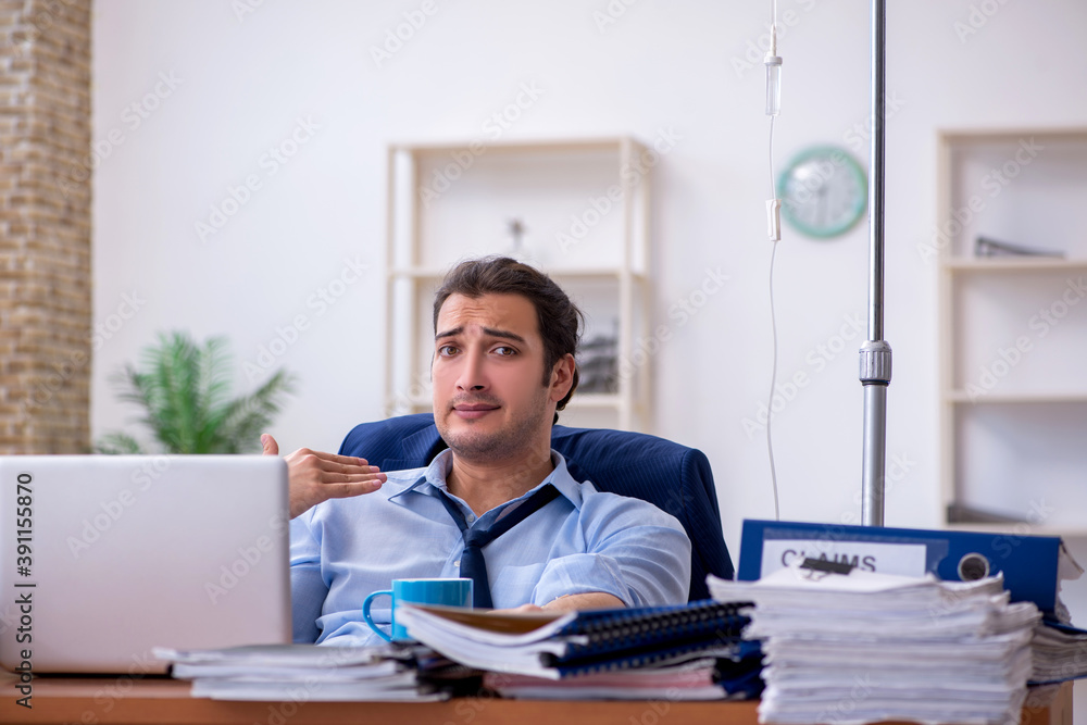 Young male employee suffering at workplace Young male employee suffering at workplace
