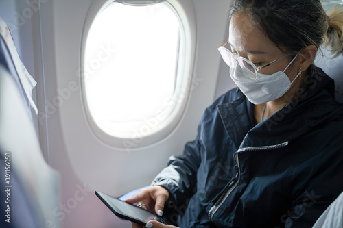 Canvas Print asian woman female air traveler reading ebook on flight